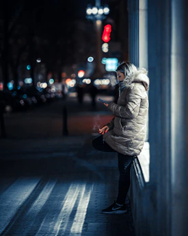 A cozy night scene showing a person chatting with an AI assistant on their phone.