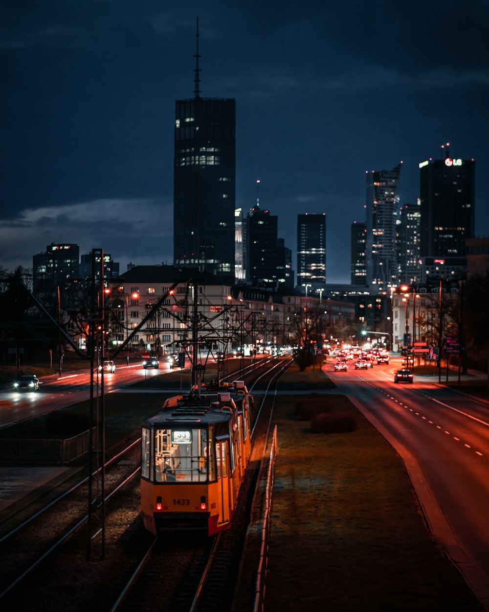 a train traveling down train tracks near a city at night