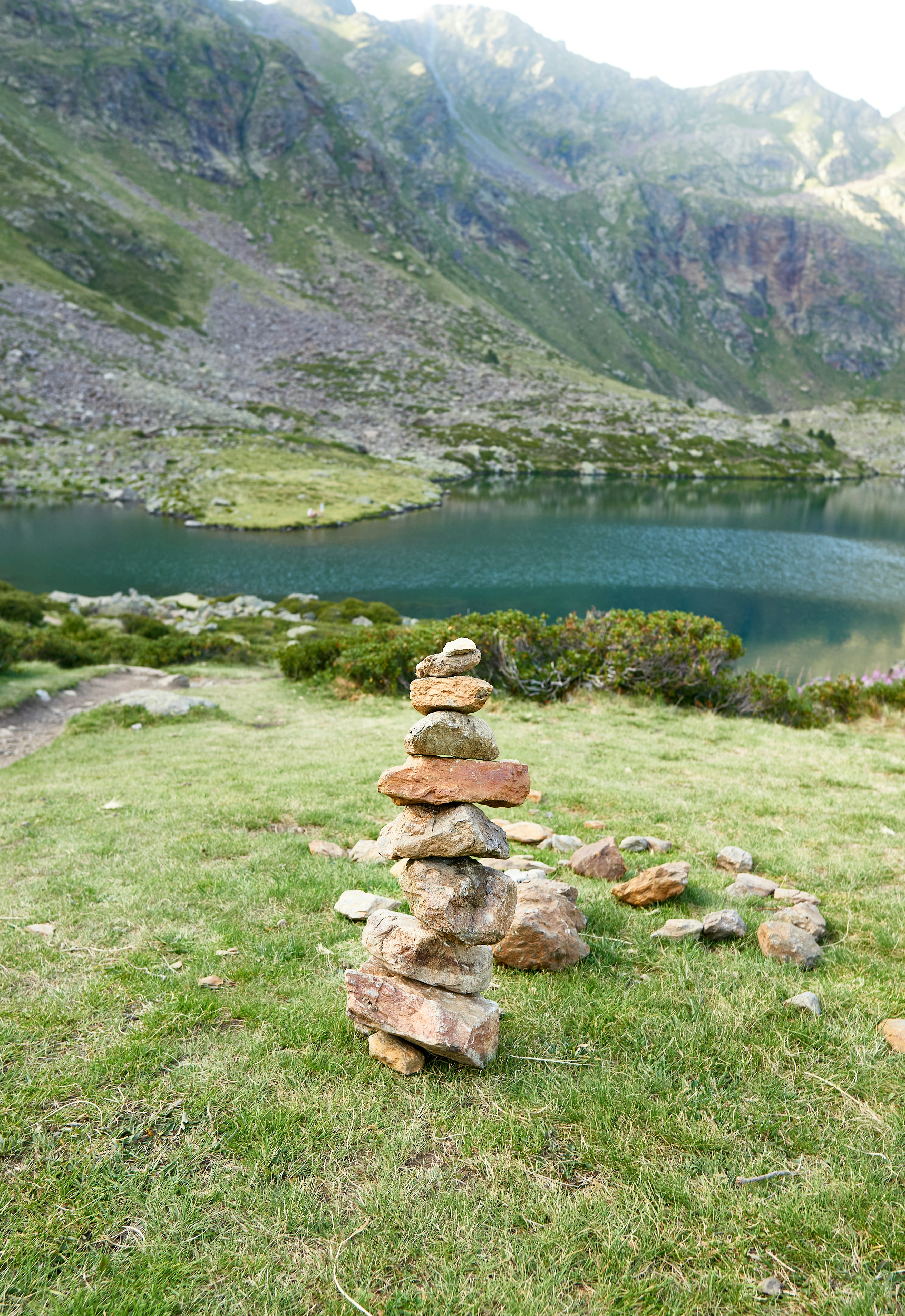 a stack of rocks sitting on top of a lush green hillside