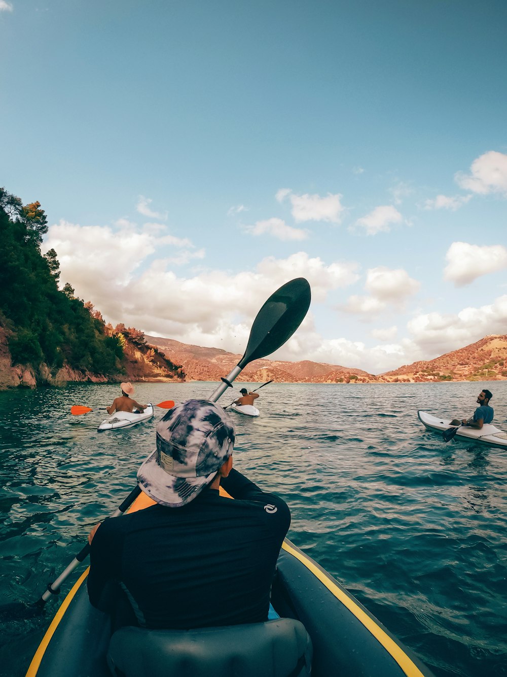Eine Gruppe von Menschen in Kajaks paddelt auf dem Wasser