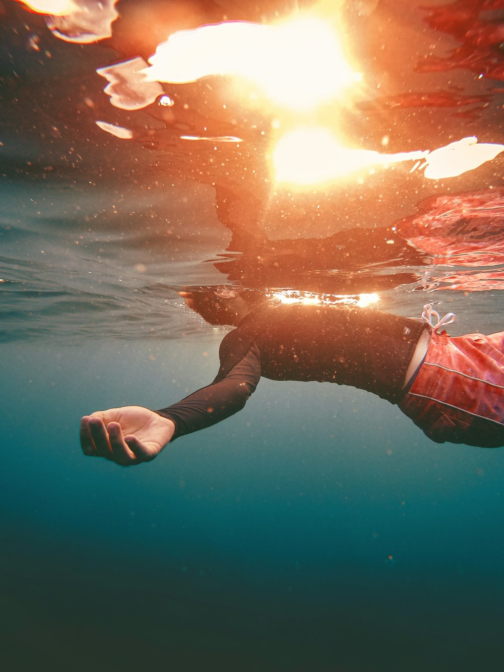 a person in a wet suit swimming in the ocean