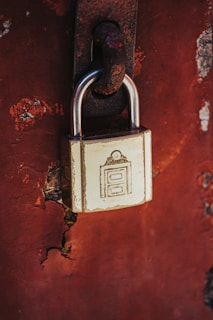 a padlock attached to a rusted red wall