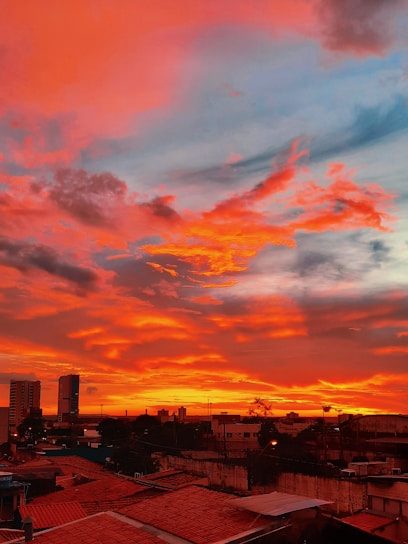 A filmmaker capturing a vibrant sunset over a city skyline.