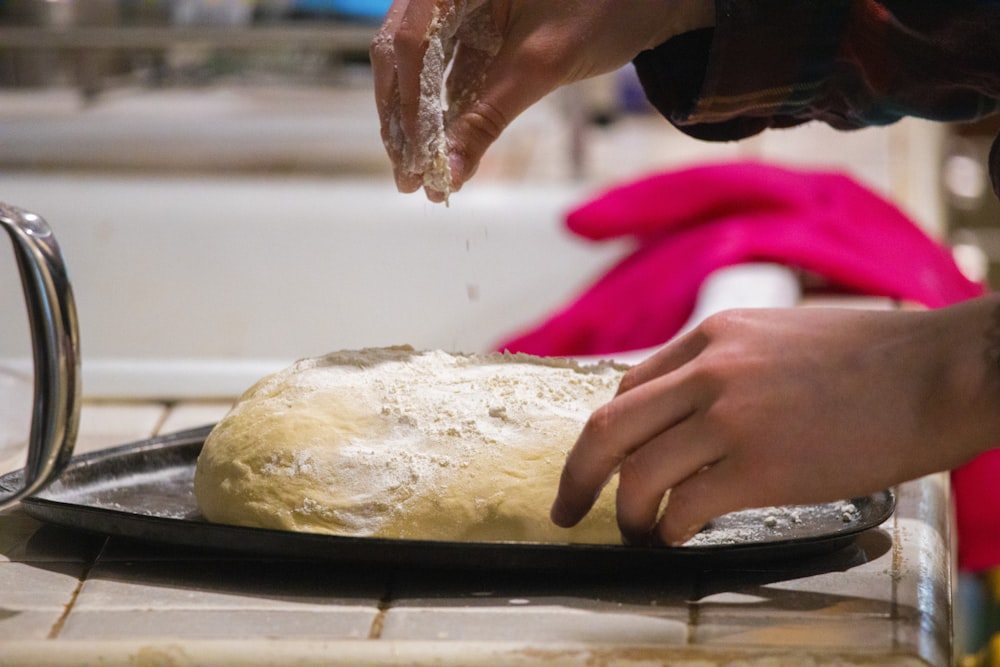 a person is kneading dough on a pan
