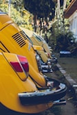 a row of yellow cars parked next to each other