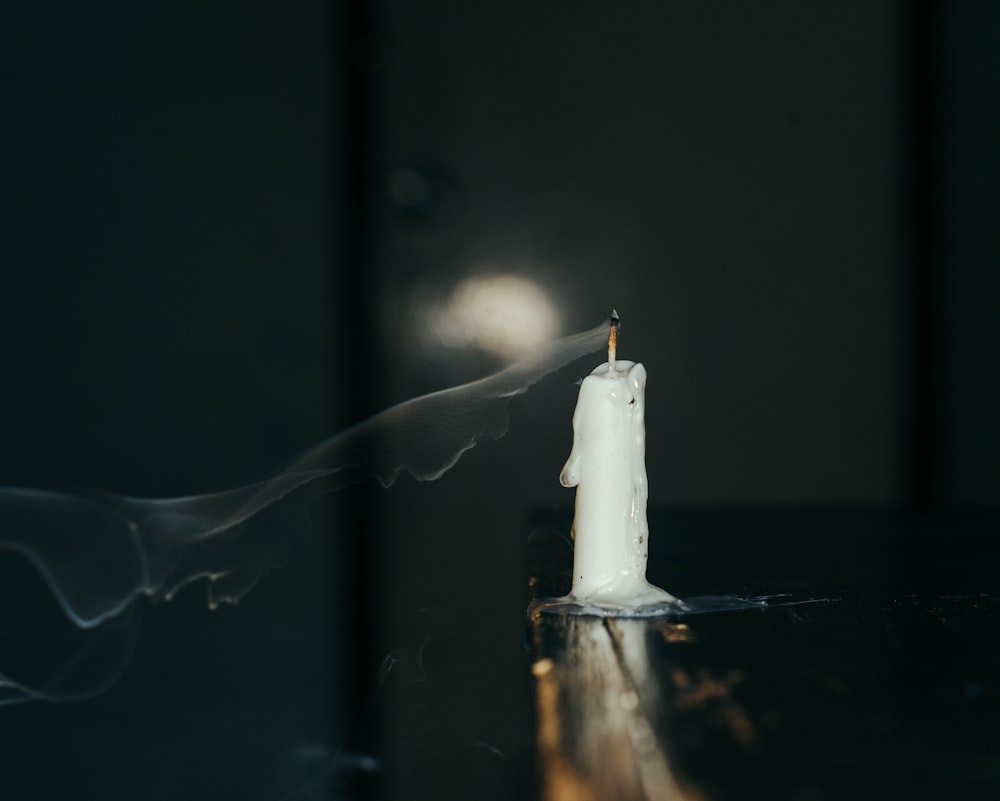 a lit candle with smoke coming out of it