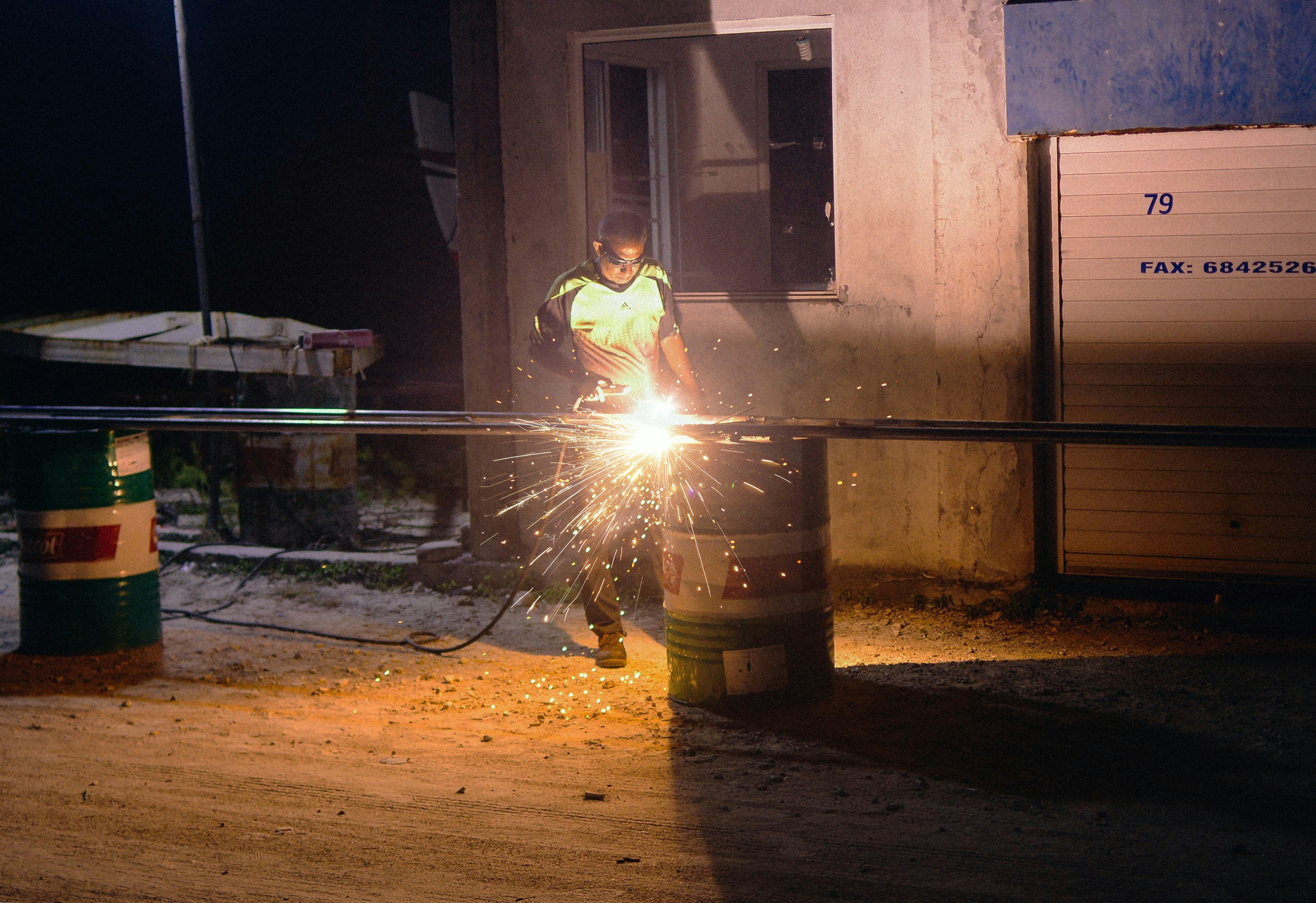 a man working with a grinder in the dark