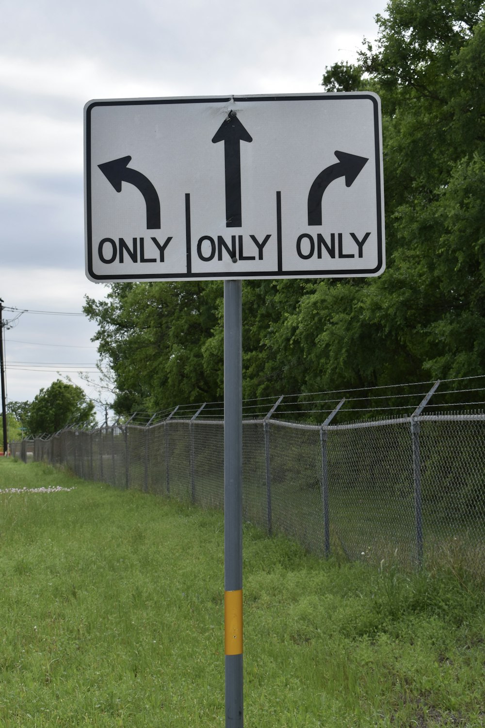 a white and black street sign on a pole