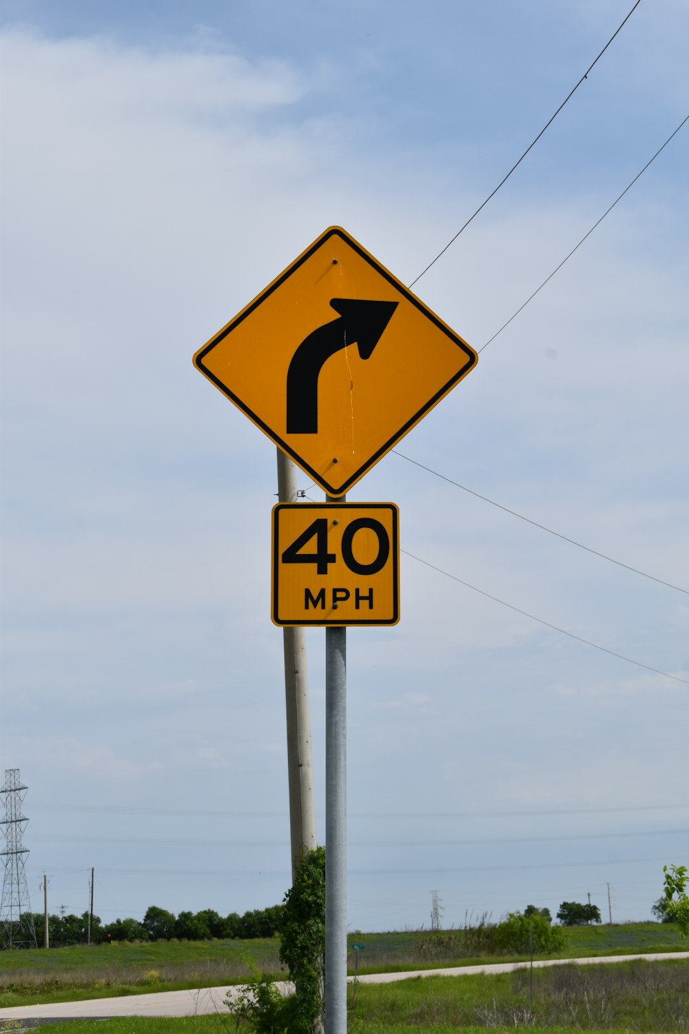 um sinal de estrada amarelo e preto em um poste