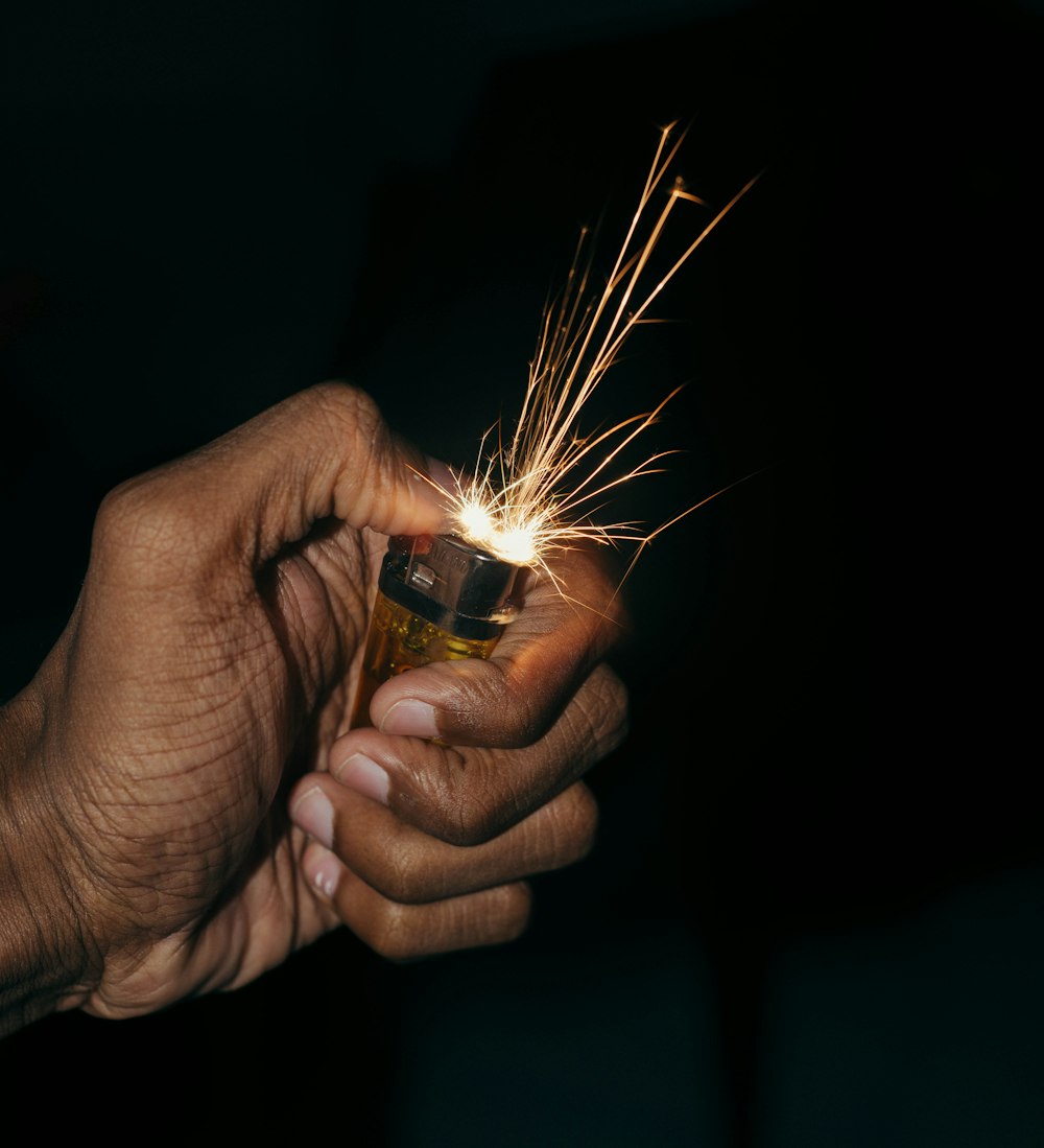 a person holding a lighter in their hand