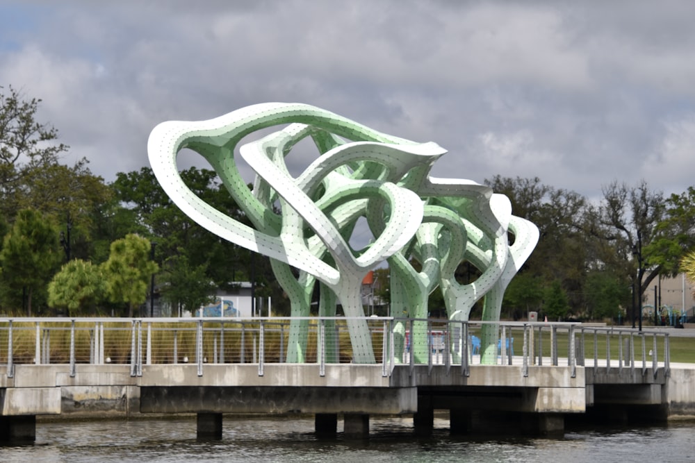 a sculpture on a bridge over a body of water