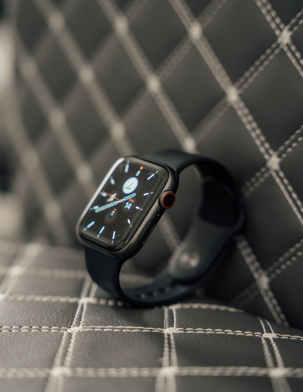 a black apple watch sitting on a couch