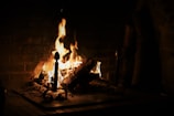 a fire burning in a fireplace in a dark room