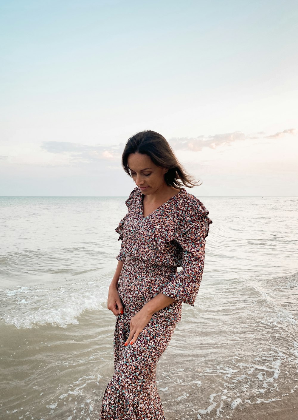 a woman standing on a beach next to the ocean