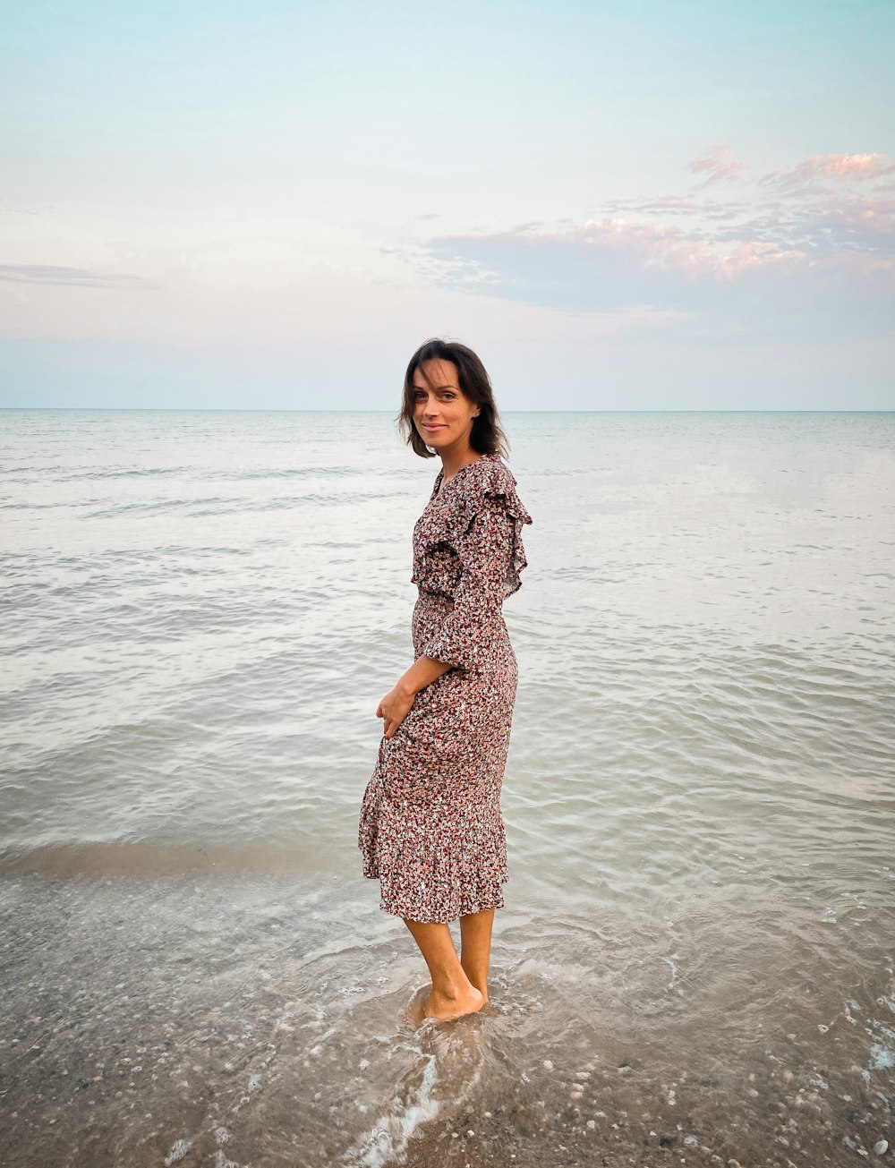 una mujer de pie en una playa junto al océano
