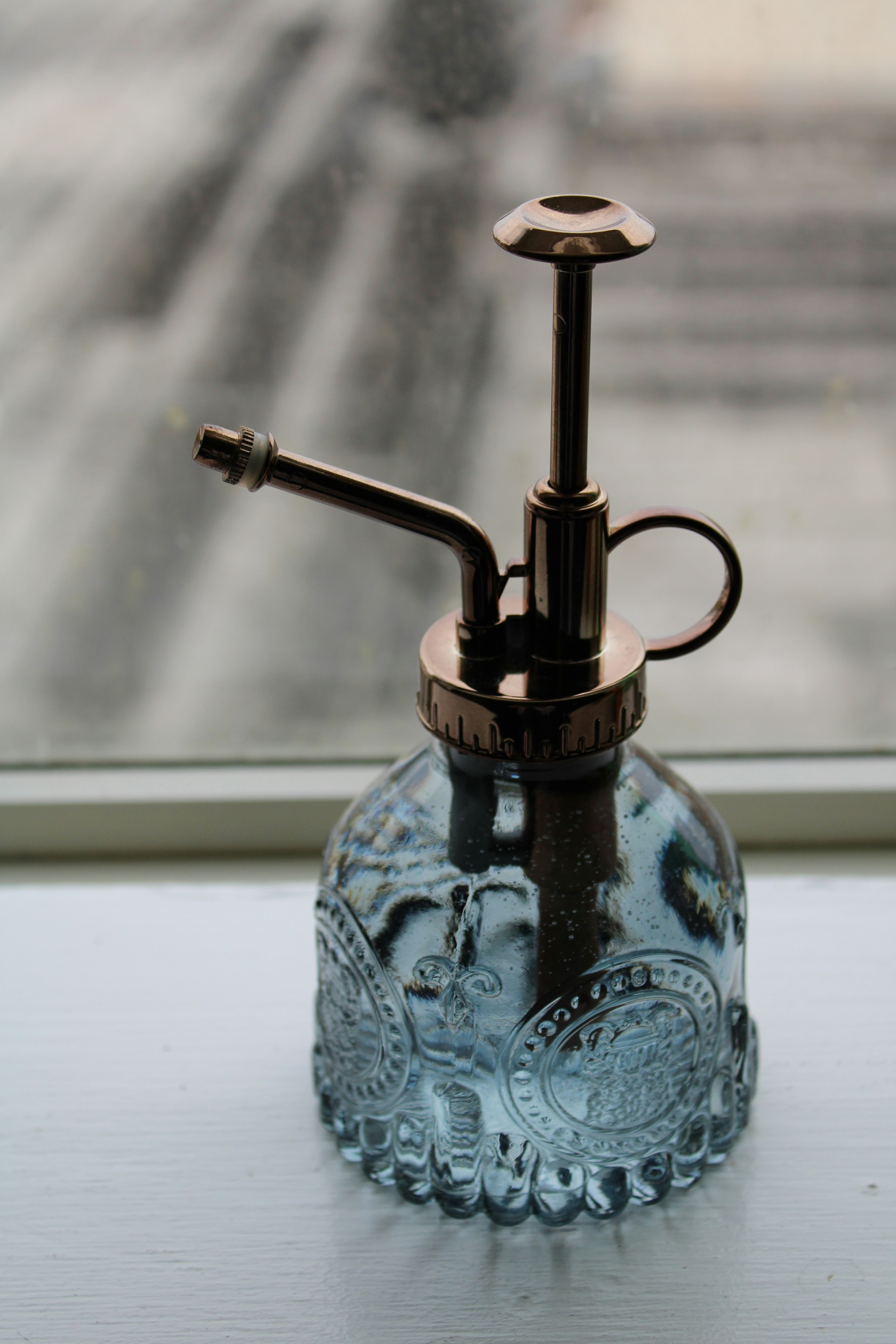 a glass bottle with a metal faucet on top of it