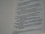 A close-up view of a page from a book presenting text in paragraph form. The text includes numbered points and is slightly blurred towards the edges, indicating shallow depth of field. The page features both bold and regular font styles indicating different emphasis on certain parts.