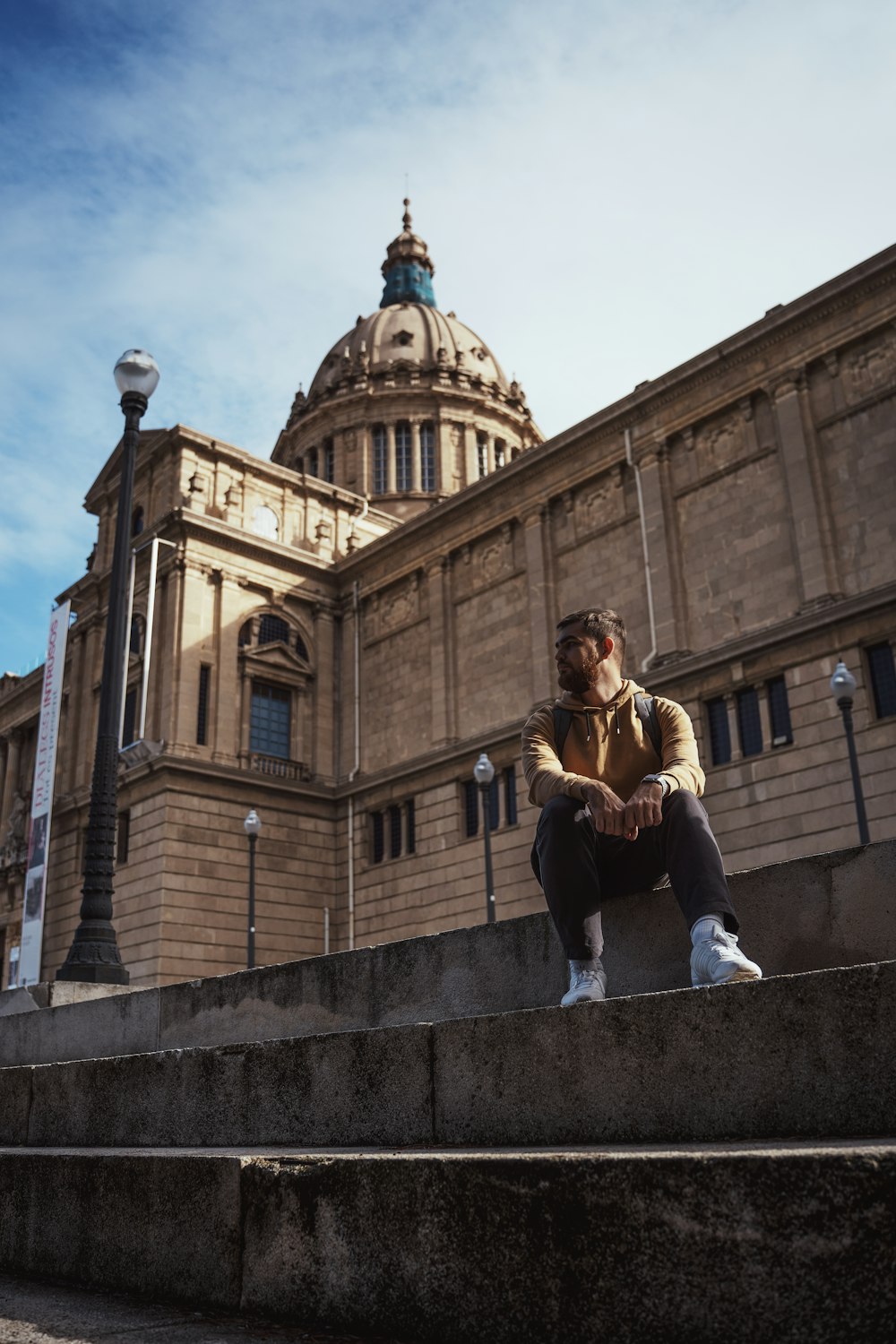 a man sitting on steps in front of a building