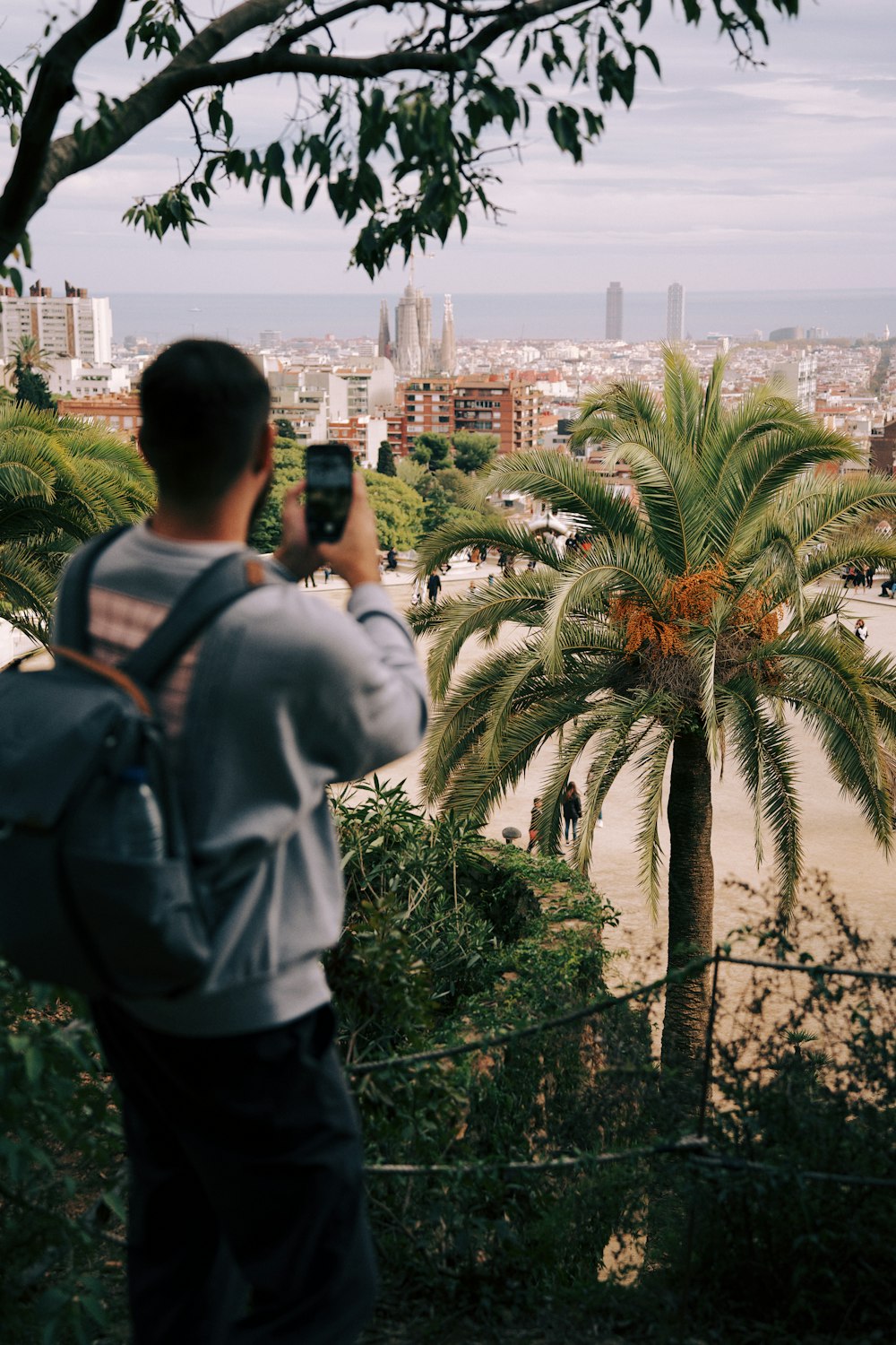 um homem tirando uma foto de uma cidade com um telefone celular