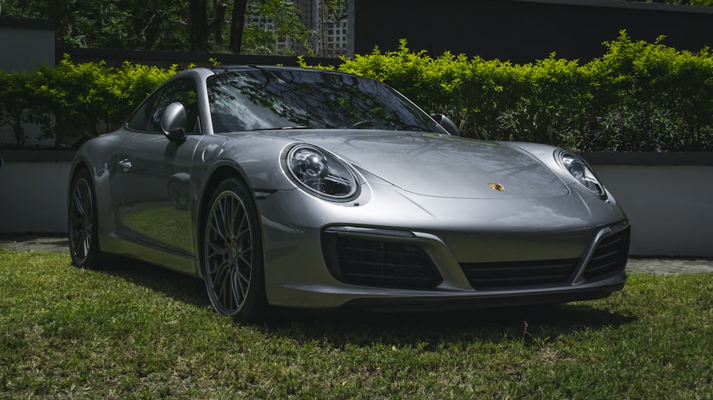 a silver sports car parked in the grass