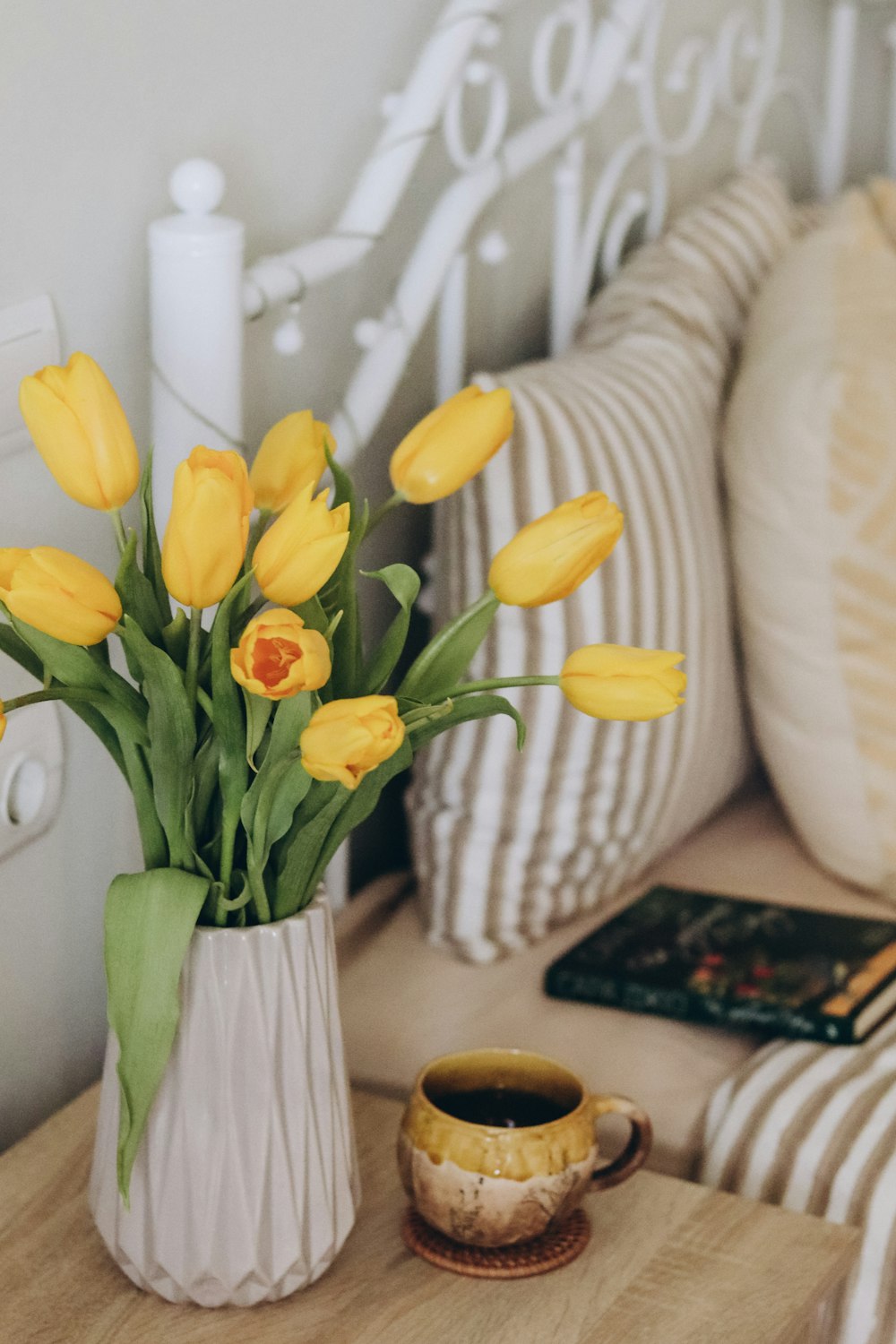 a vase of yellow tulips sitting on a table