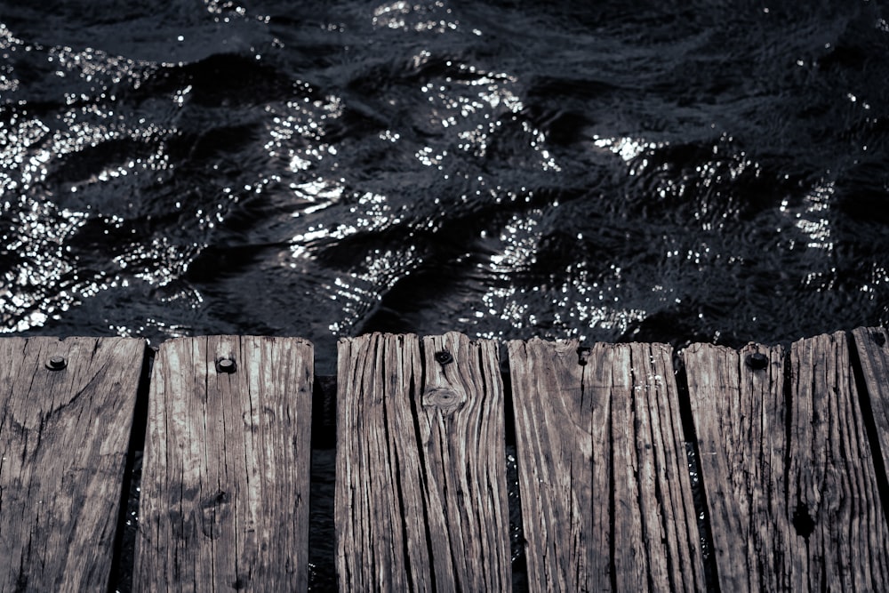 eine Nahaufnahme eines hölzernen Docks mit Wasser im Hintergrund
