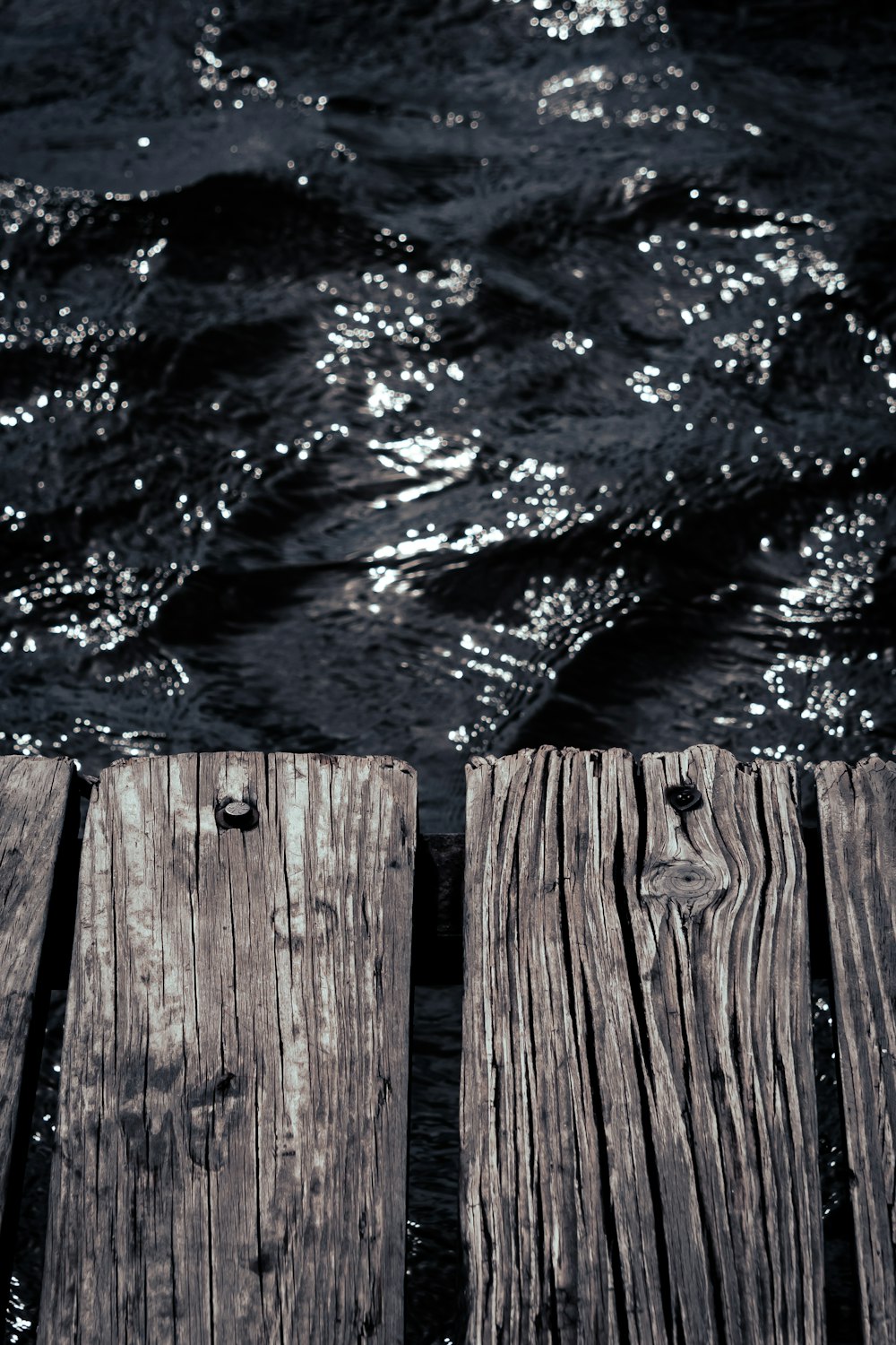 a close up of a wooden dock with water in the background