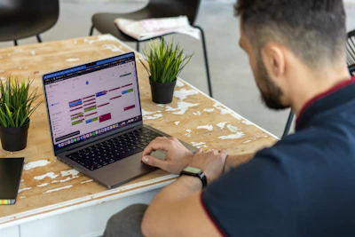 a man sitting at a table using a laptop computer