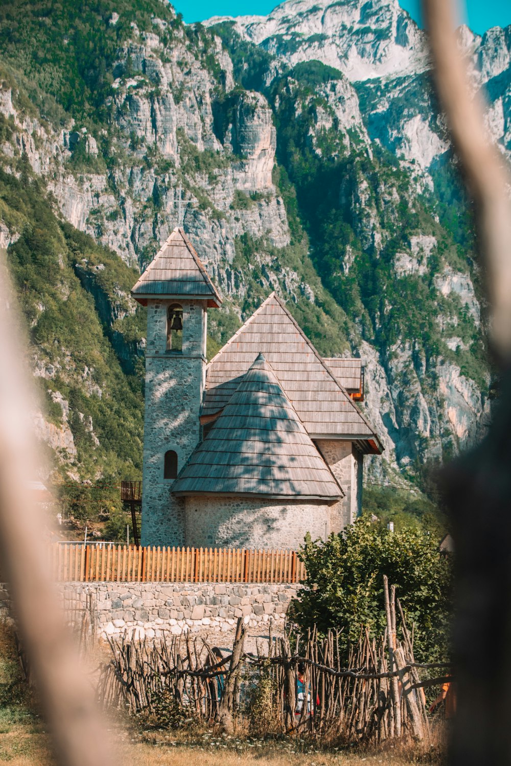 a building with a steeple in front of a mountain