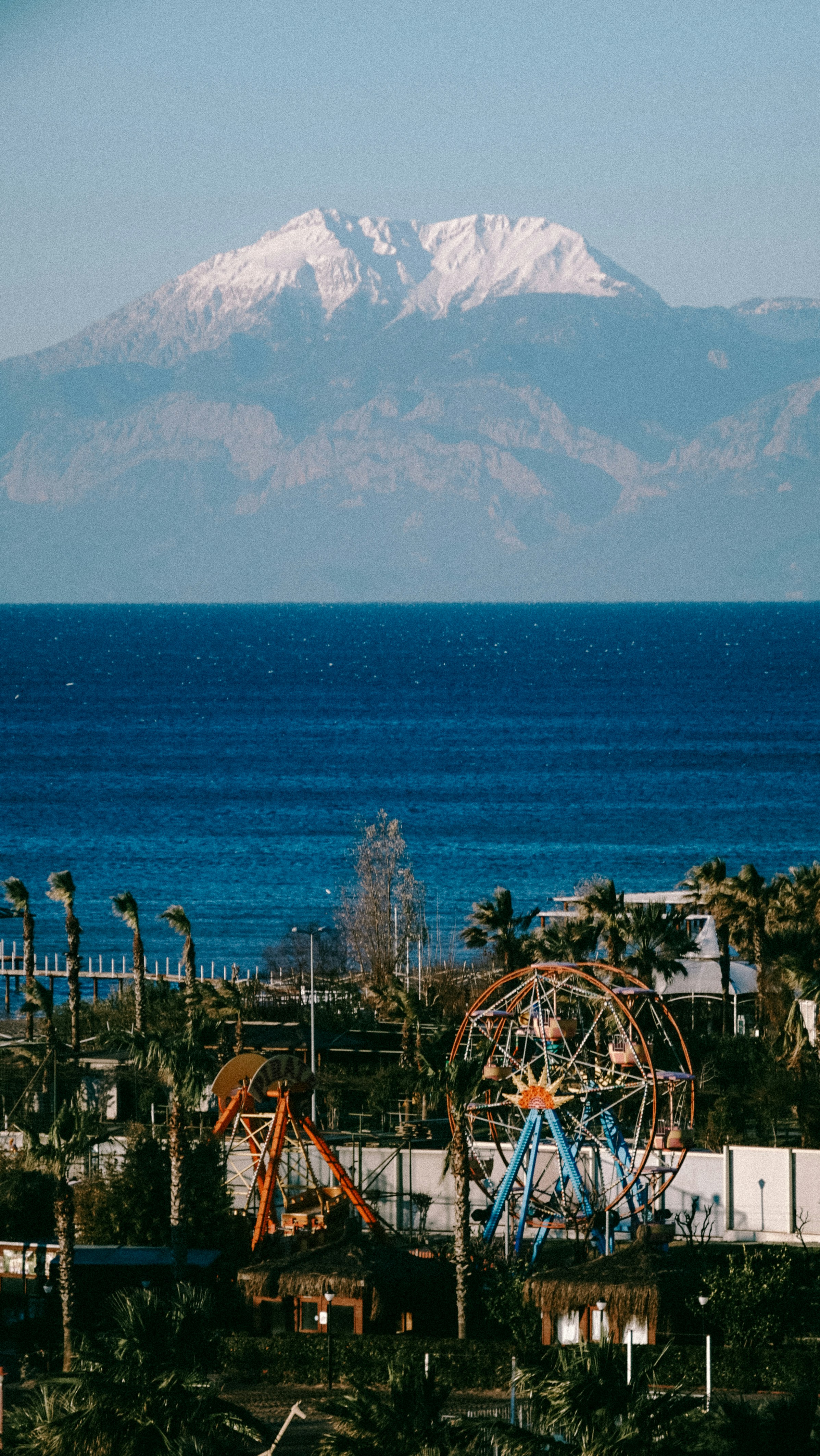 a view of a mountain with a ferris wheel in the foreground