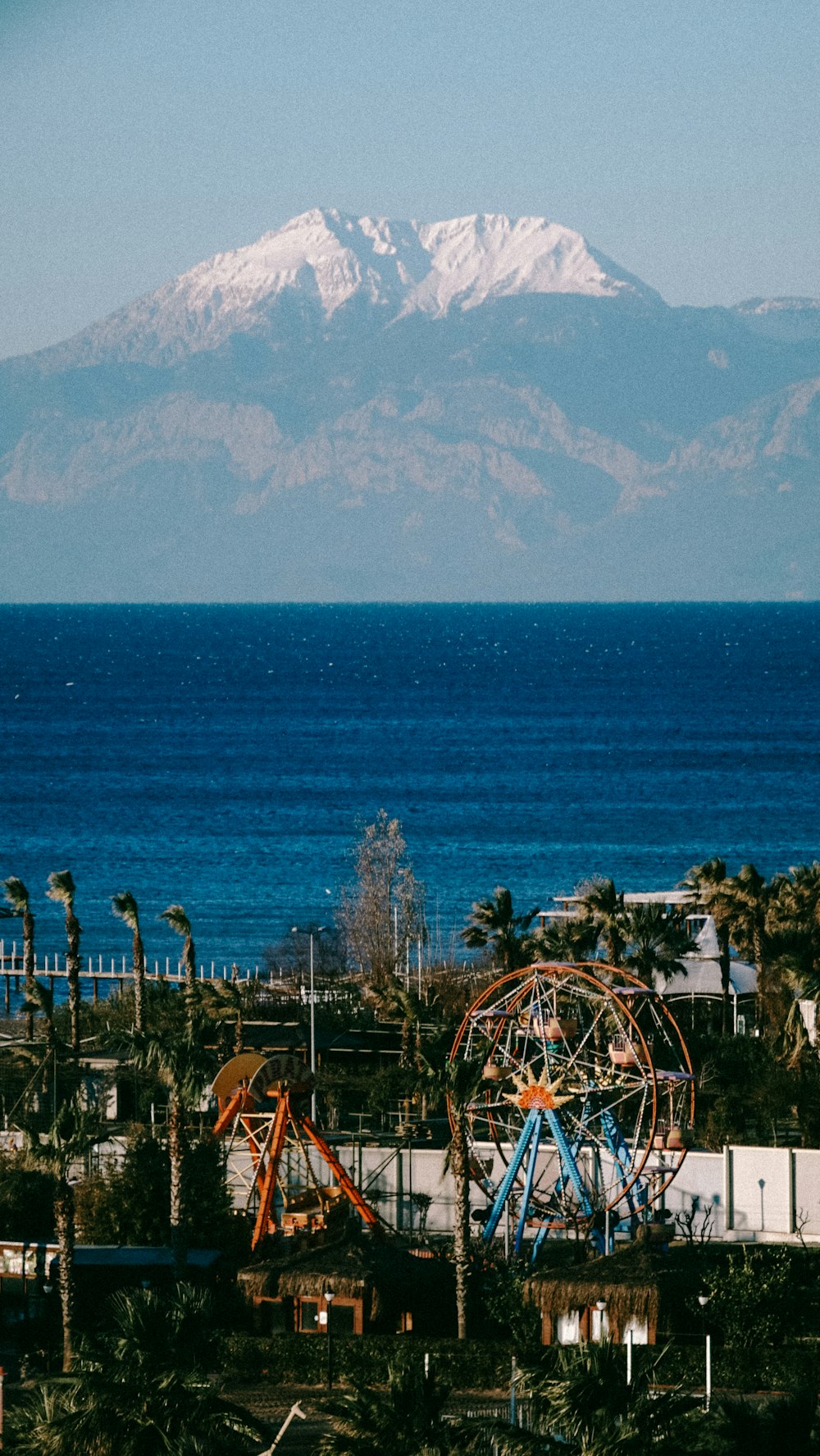 a view of a mountain with a ferris wheel in the foreground