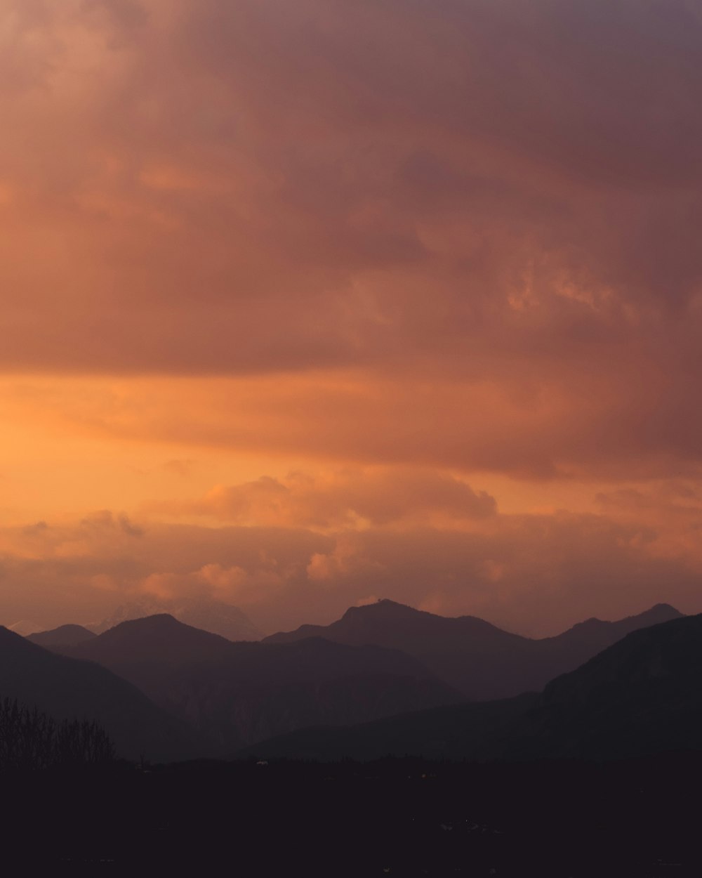 a plane flying in the sky with mountains in the background