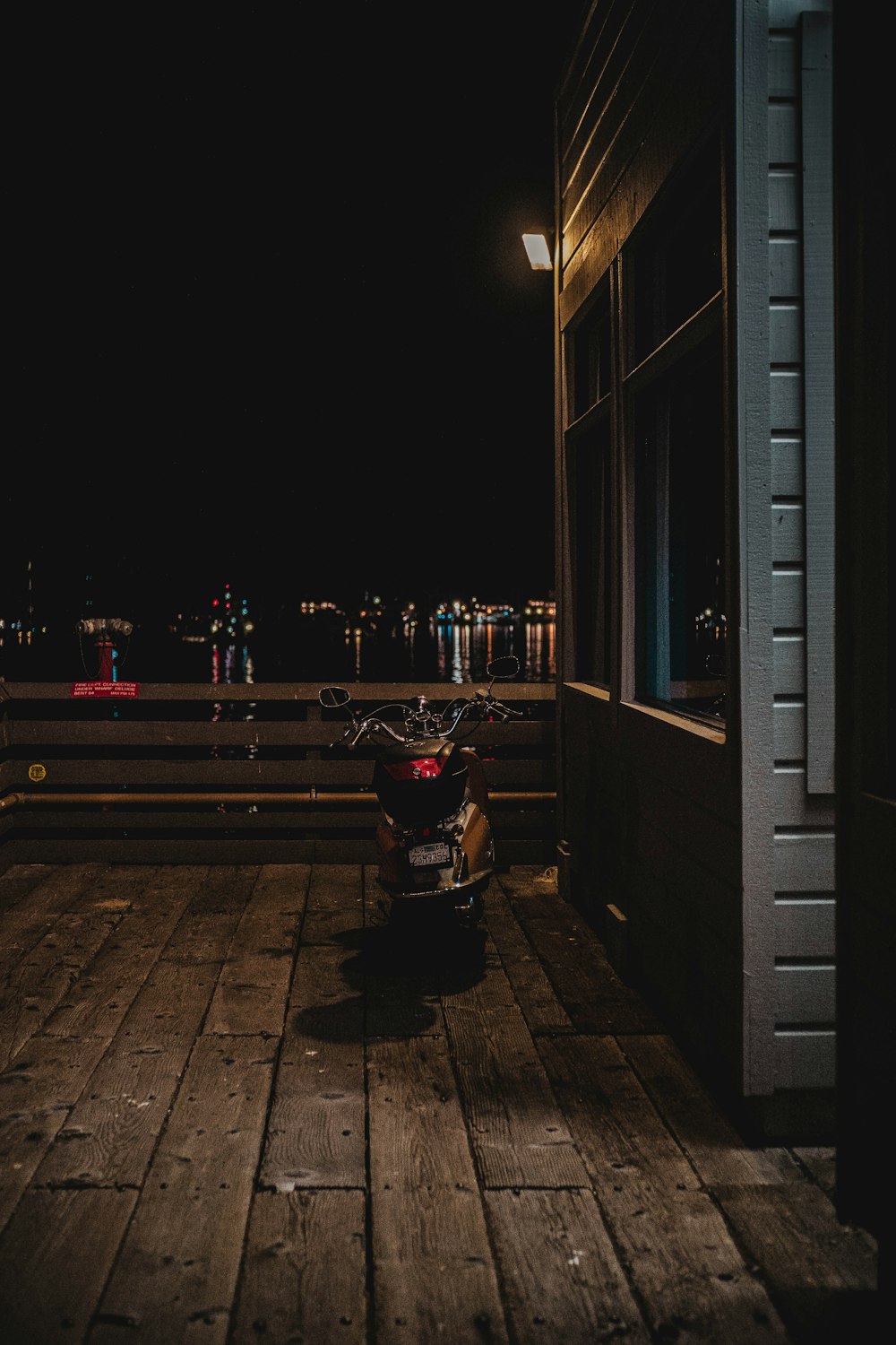 a motorcycle parked on a wooden deck at night