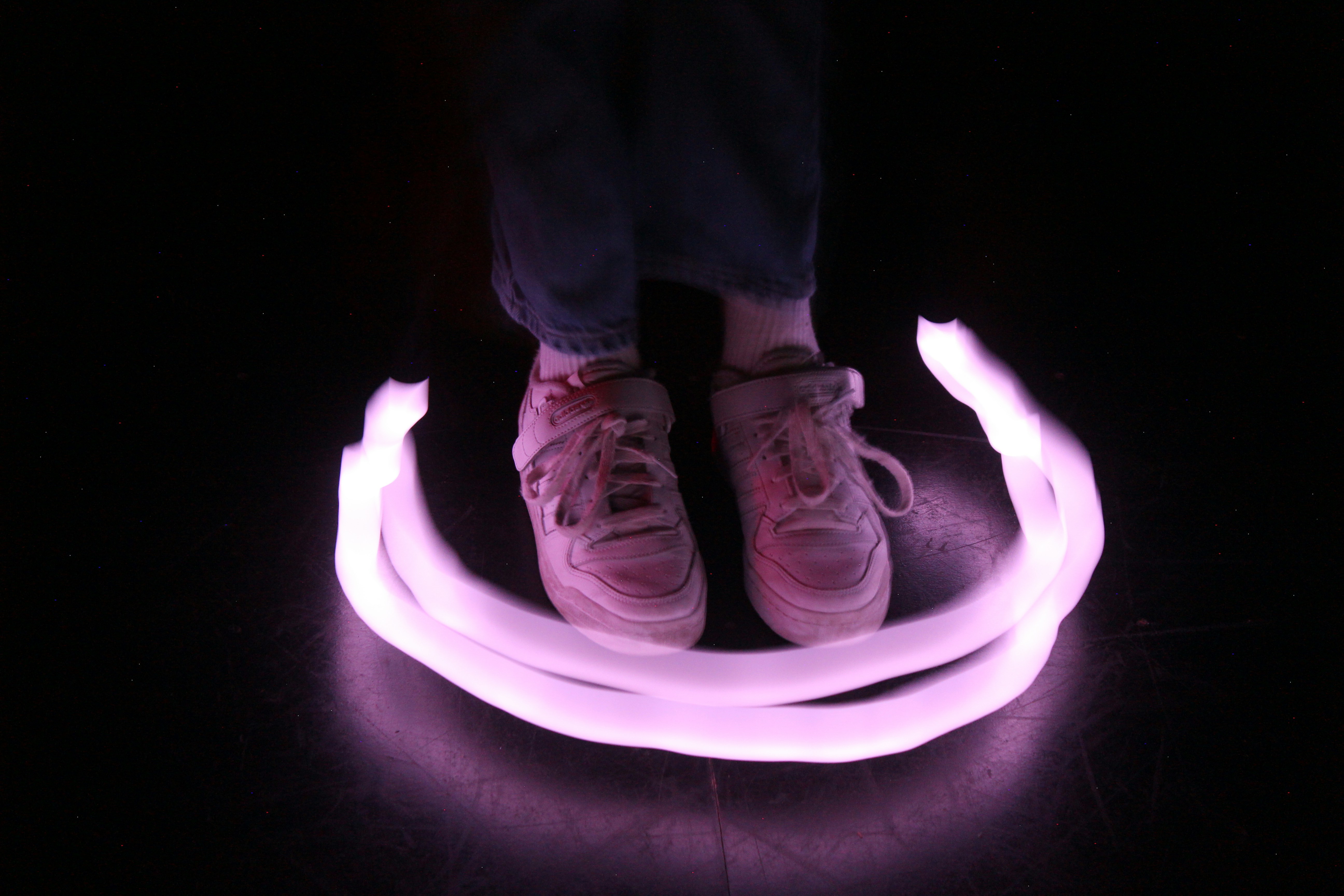 a person standing on top of a purple light