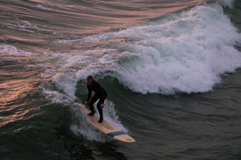 um homem montando uma prancha de surf em uma onda no oceano