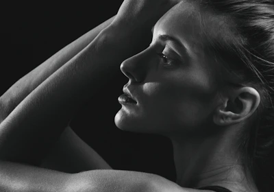 a black and white photo of a woman with her hands on her head