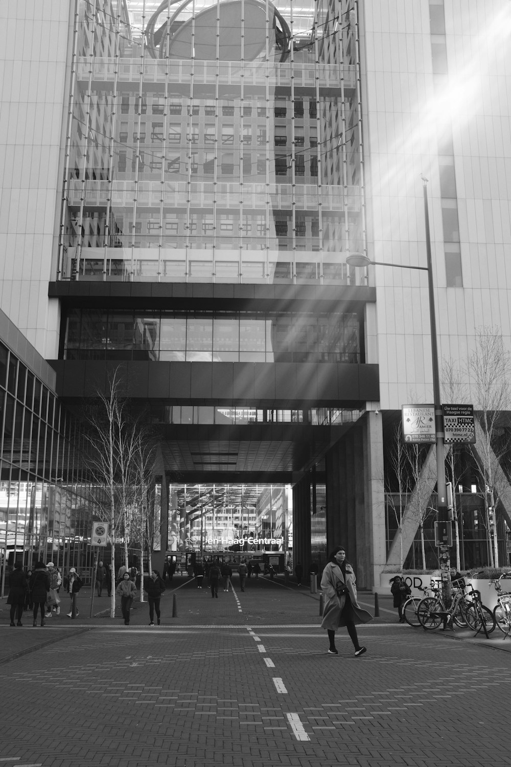 a black and white photo of people walking in front of a building