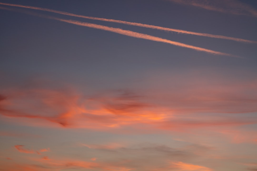a sunset with contrails in the sky,