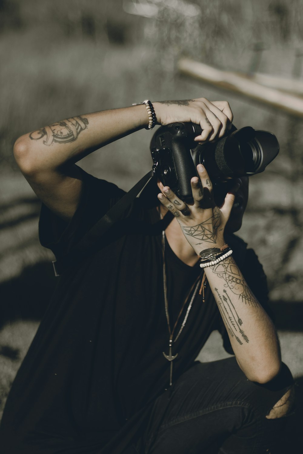 a man sitting on the ground taking a picture with a camera