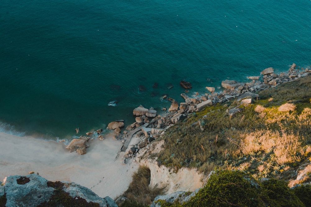 an aerial view of a beach with rocks and water