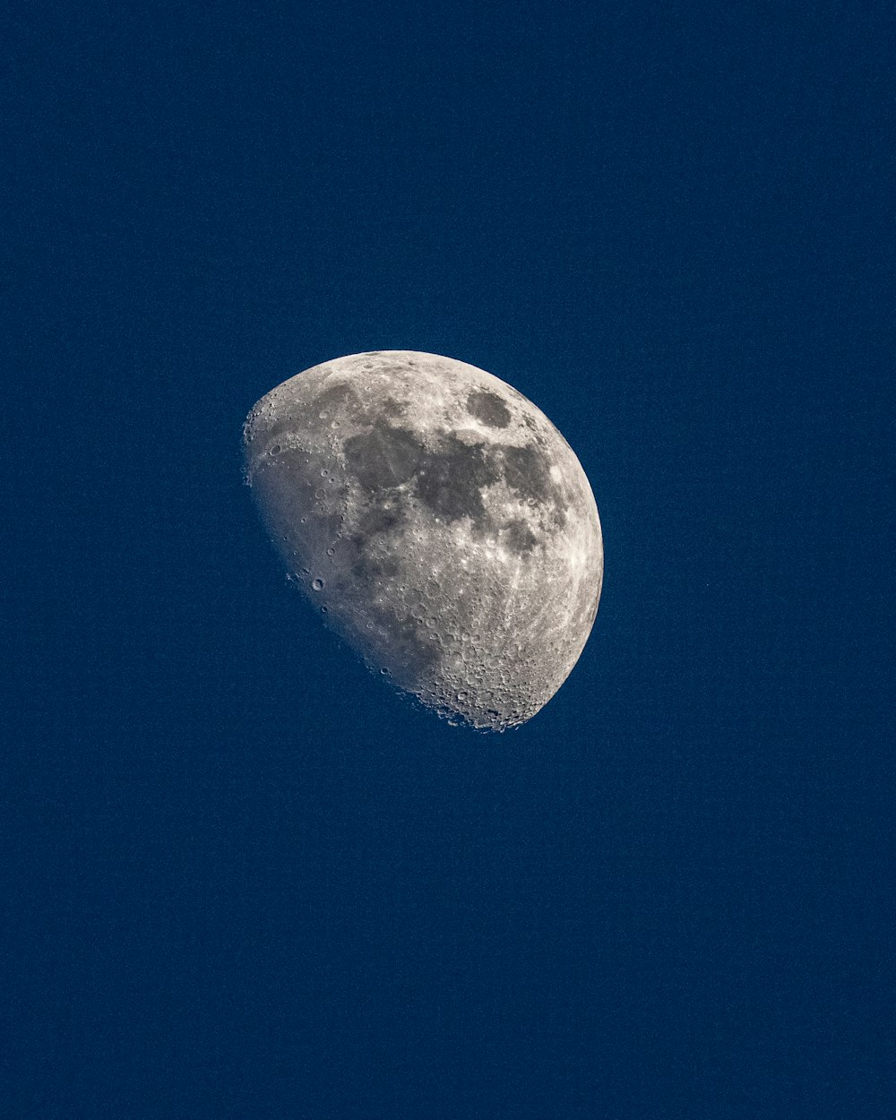 a half moon in a clear blue sky