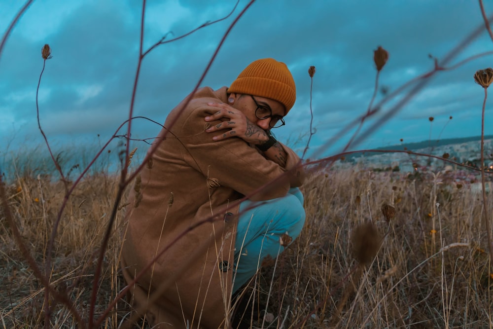 a man sitting in a field of tall grass