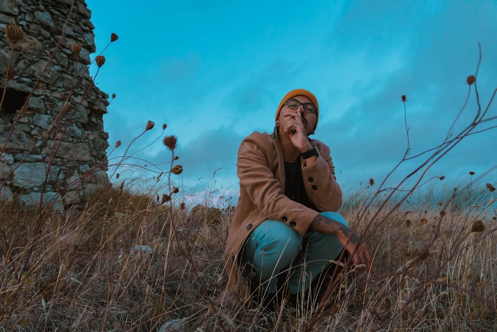 a man sitting in a field of tall grass