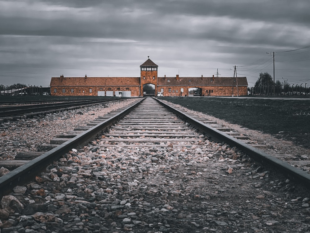 um trilho de trem com um edifício ao fundo