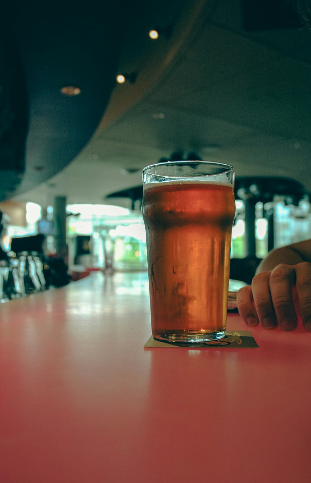 a glass of beer sitting on top of a table