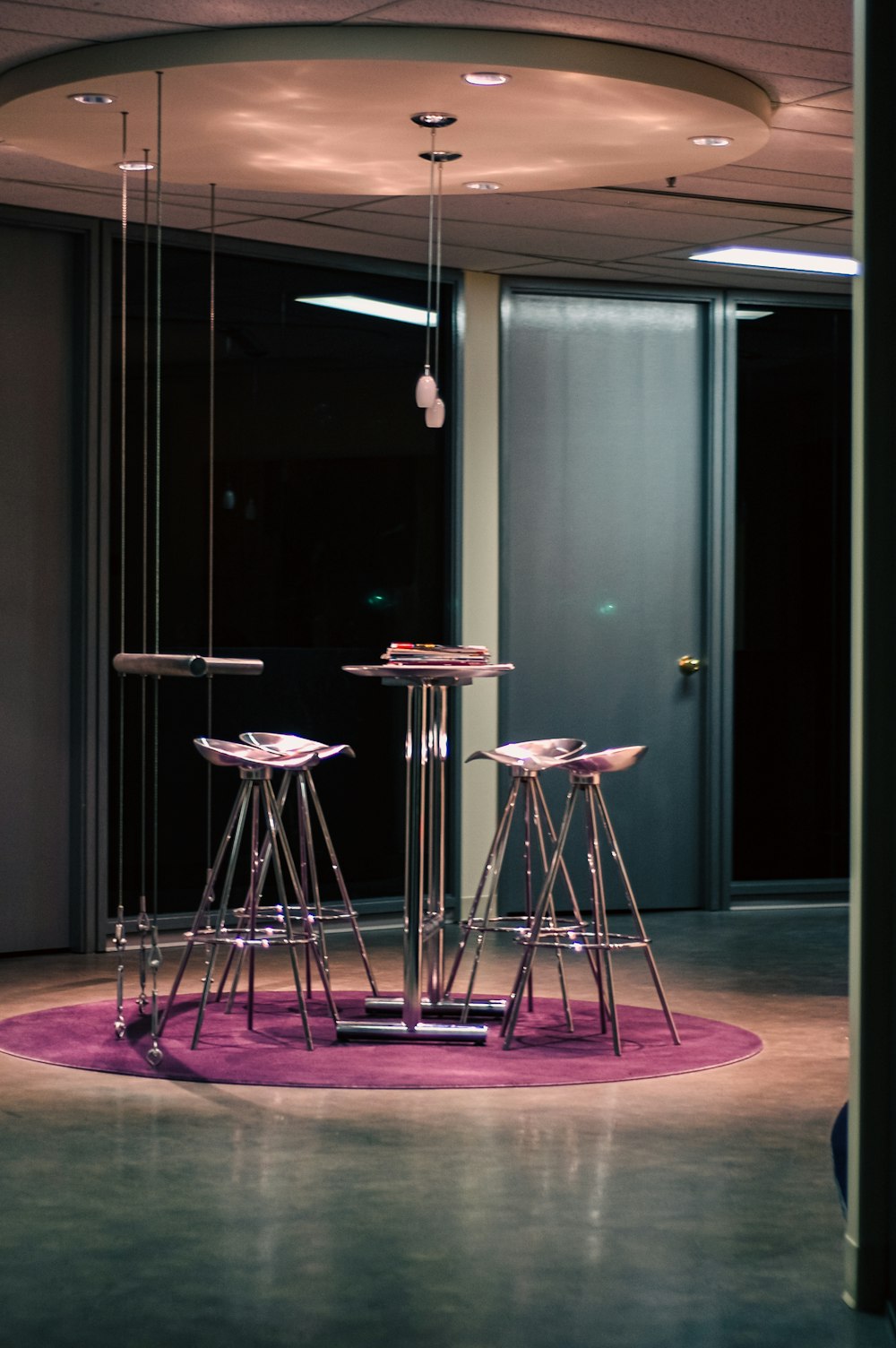 a room with a round table and four stools