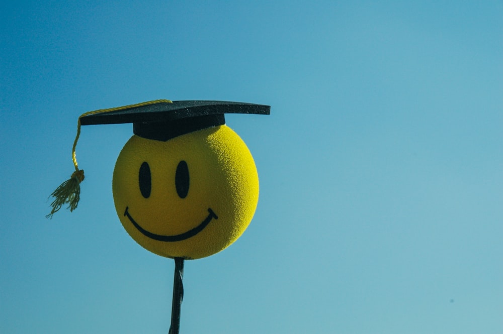 a smiley face wearing a graduation cap