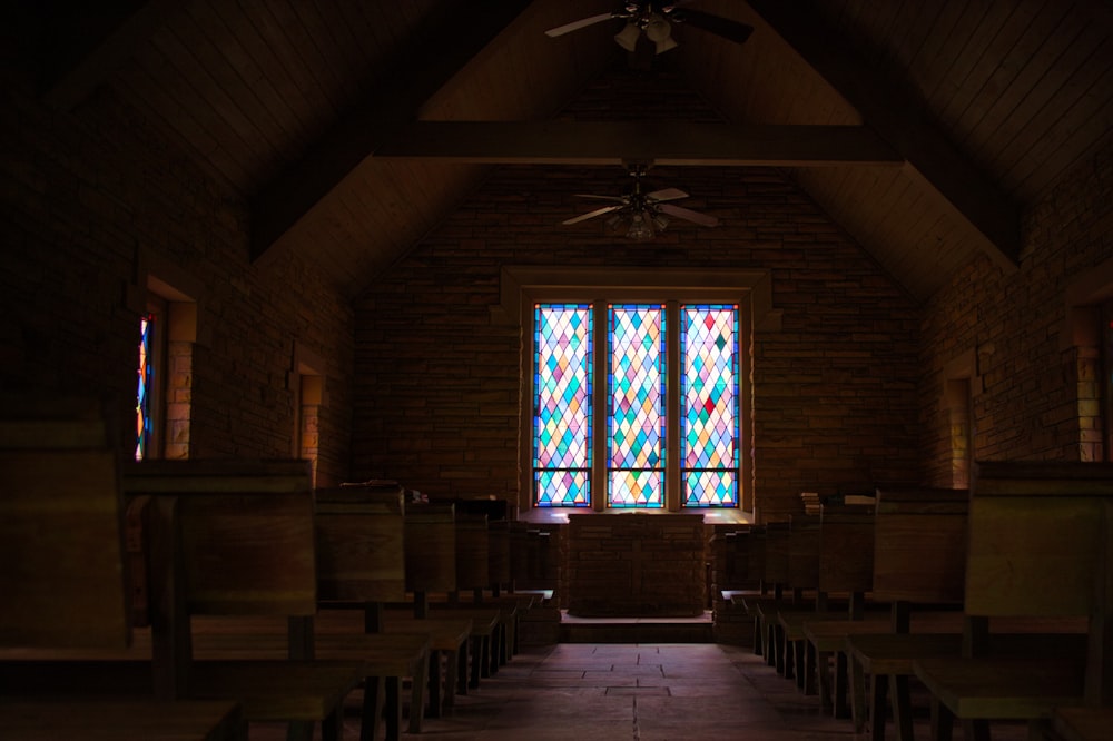 eine Kirche mit Buntglasfenstern und Kirchenbänken