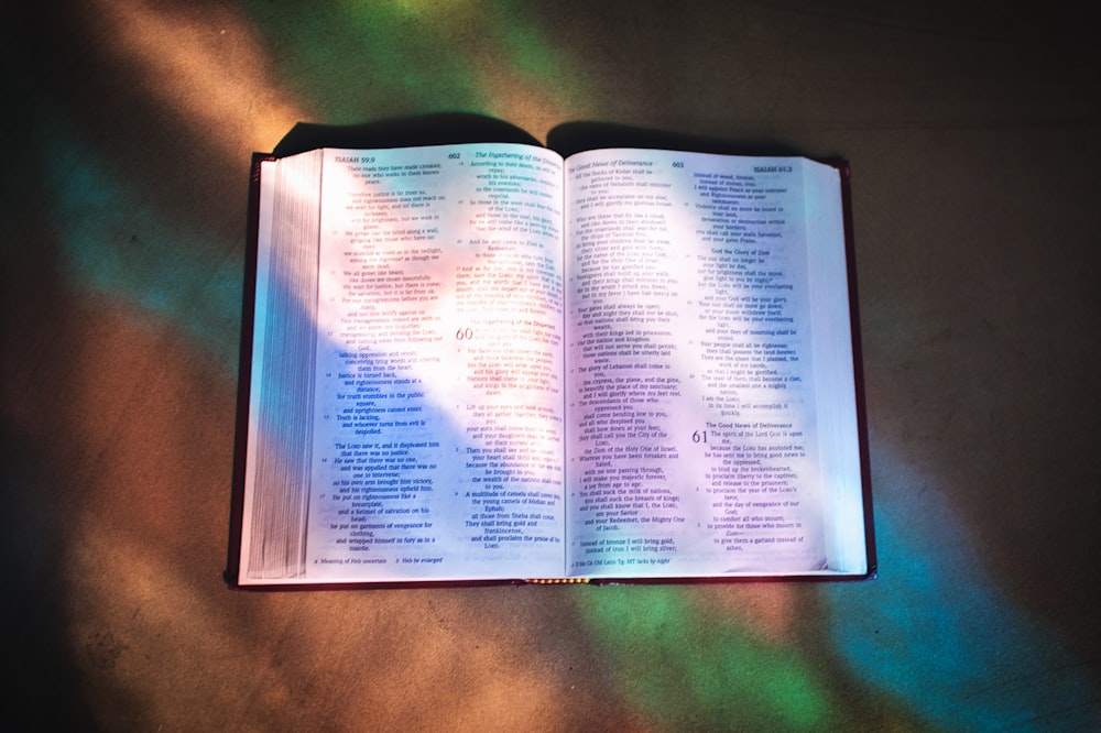 uma bíblia aberta em uma mesa à luz do sol