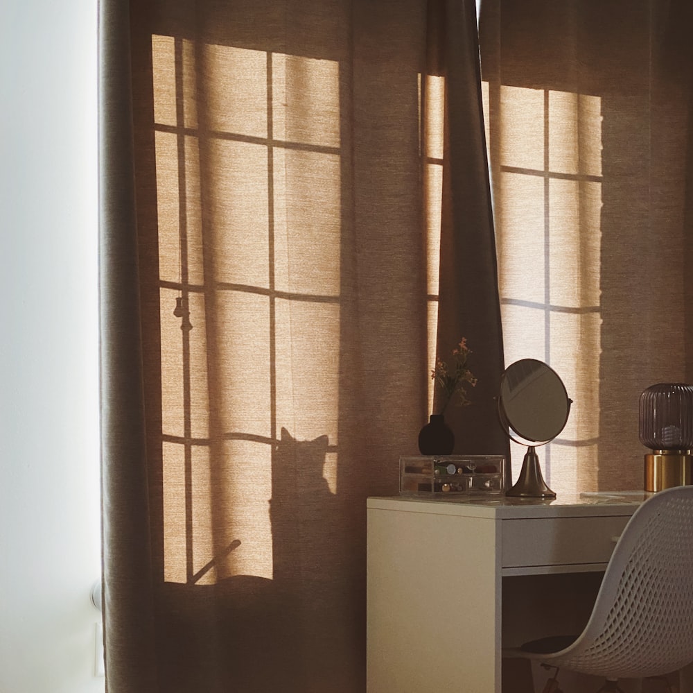 a desk with a chair and a mirror in a room